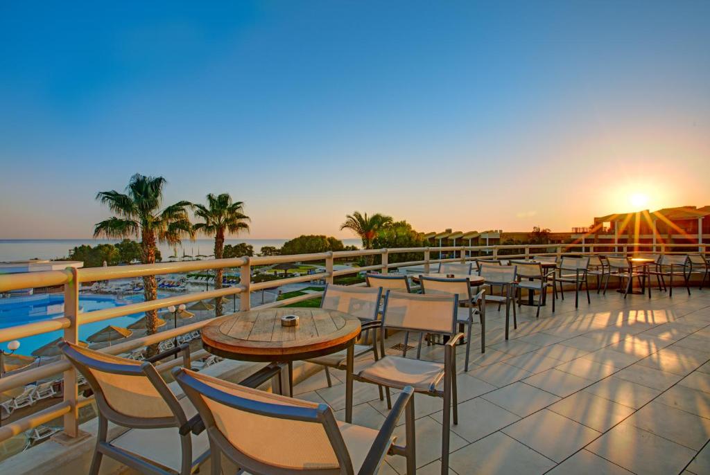 a patio with tables and chairs and the ocean at TUI Magic Life Candia Maris - Adults Only in Amoudara Herakliou