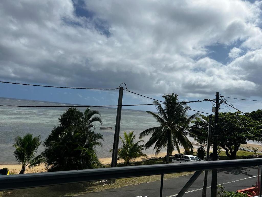 a view of a beach with palm trees and the ocean at Blue sea in Ruisseau Créole