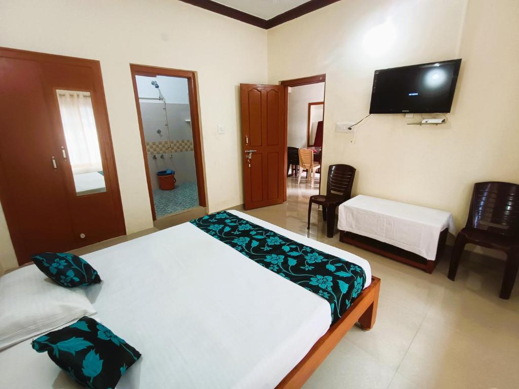 um quarto com uma cama e uma televisão na parede em Coorg Cardamom Estate Stay em Madikeri