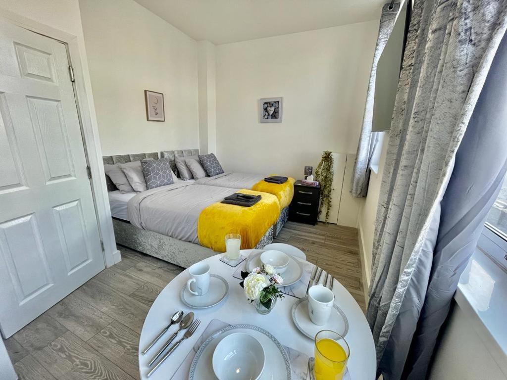 een kleine kamer met een bed en een tafel met borden bij Cardiff City Centre Apartment- Penarth Road in Cardiff