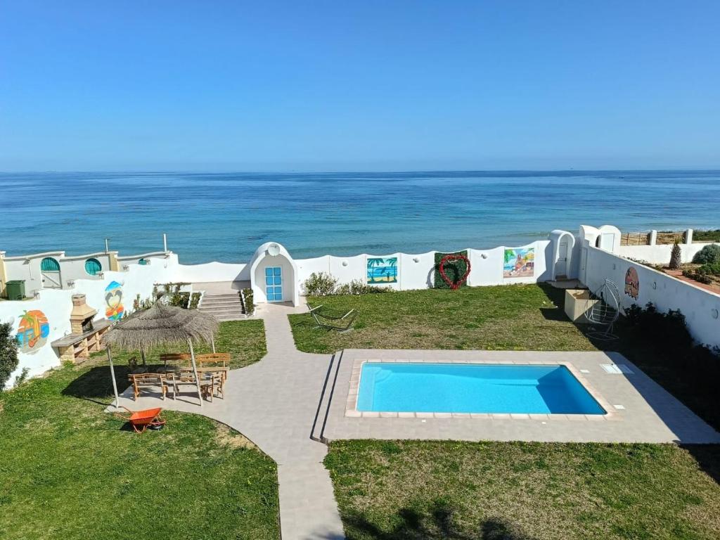 a view of a swimming pool and the ocean at Dar Riahi Ras Jbal in Raʼs al Jabal