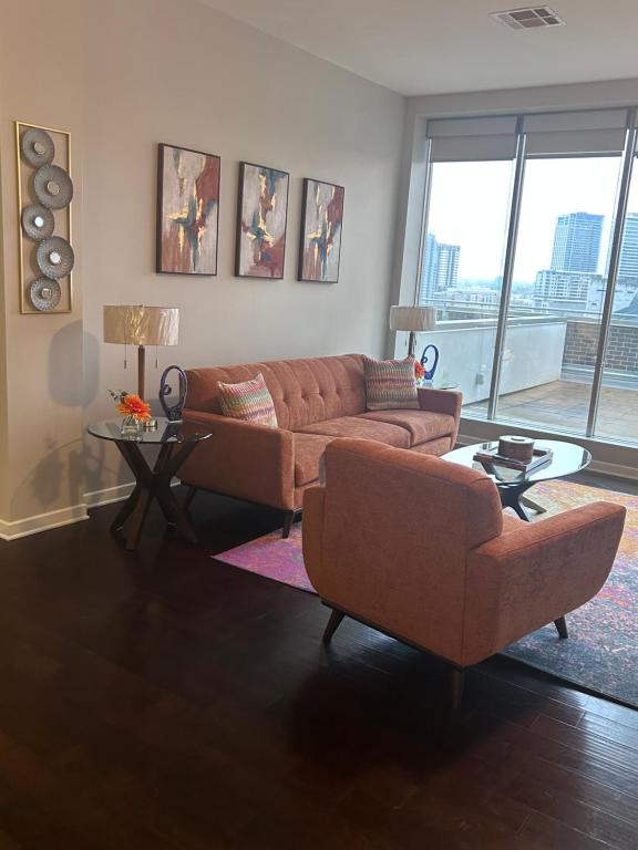 a living room with two couches and a table at On The Go Stays(Penthouse) in Dallas