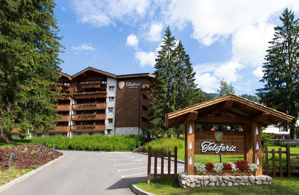 a hotel with a sign in front of a parking lot at Teleferic Grand Hotel in Poiana Brasov