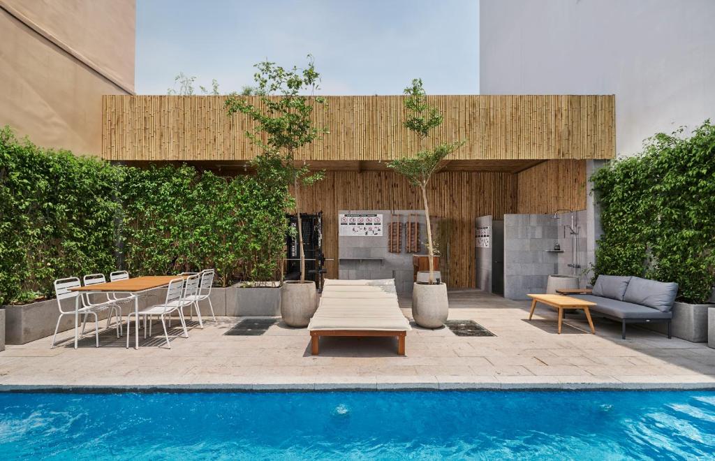 um pátio com uma mesa, uma mesa e uma piscina em Sky Gem Hotel - Ben Thanh em Ho Chi Minh