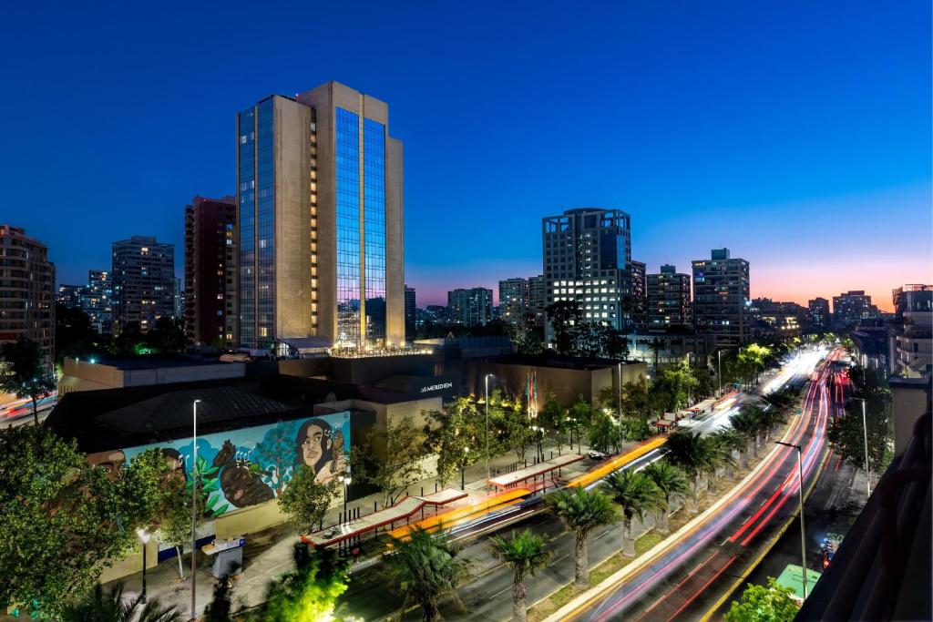 um horizonte da cidade à noite com um comboio em Le Méridien Santiago by Marriott em Santiago