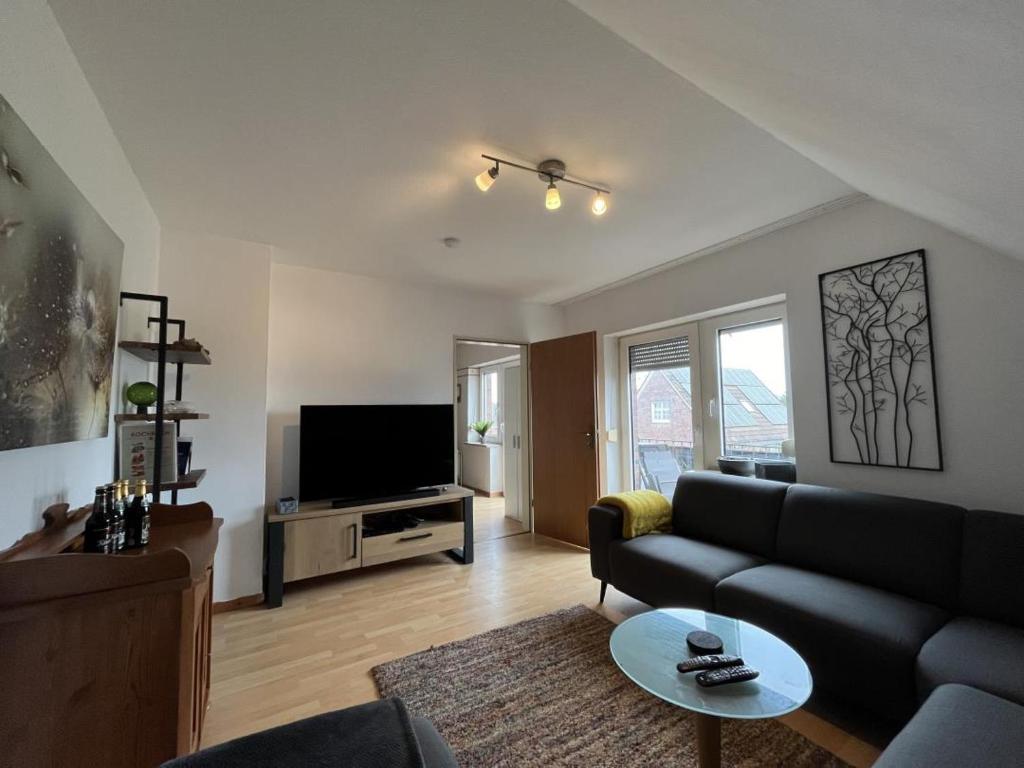 een woonkamer met een bank en een tv bij Nordseekrabbe in Holtgast