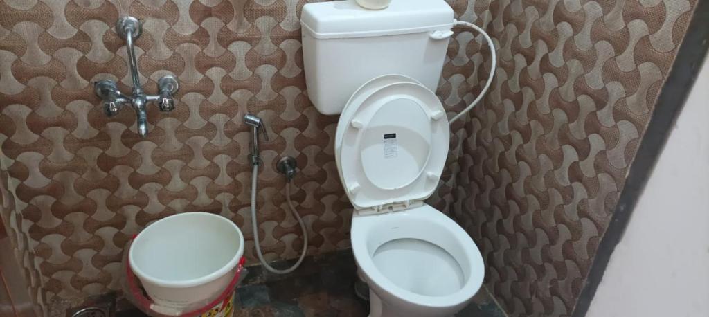 a small bathroom with a toilet and a sink at NEW GREEN MOUNTAIN RESIDENCY in Ooty