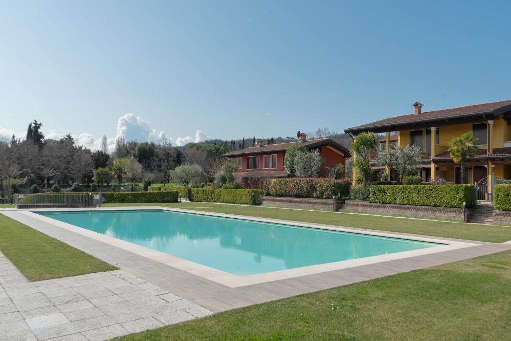 a swimming pool in a yard next to a house at Residence Garda Sole 3-69 by Wonderful Italy in Padenghe sul Garda