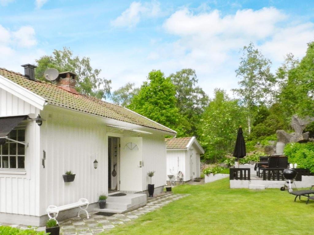a white cottage with a garden and a patio at Holiday Home Sörkila in Lysekil