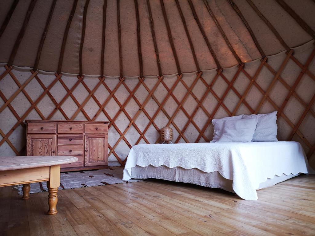 a bedroom in a yurt with a bed and a table at Yourte au coeur du village in Fontvieille
