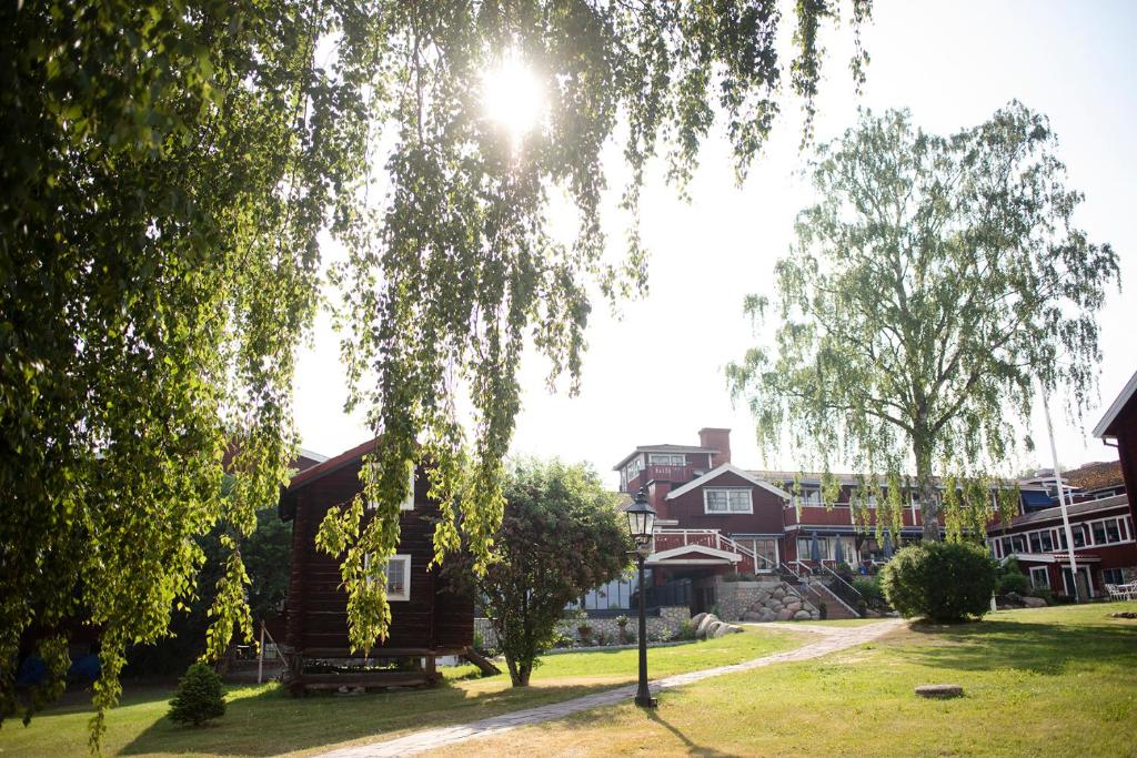 drewniany domek ze słońcem świecącym przez drzewo w obiekcie Åkerblads Hotell Gästgiveri Spa w mieście Tällberg
