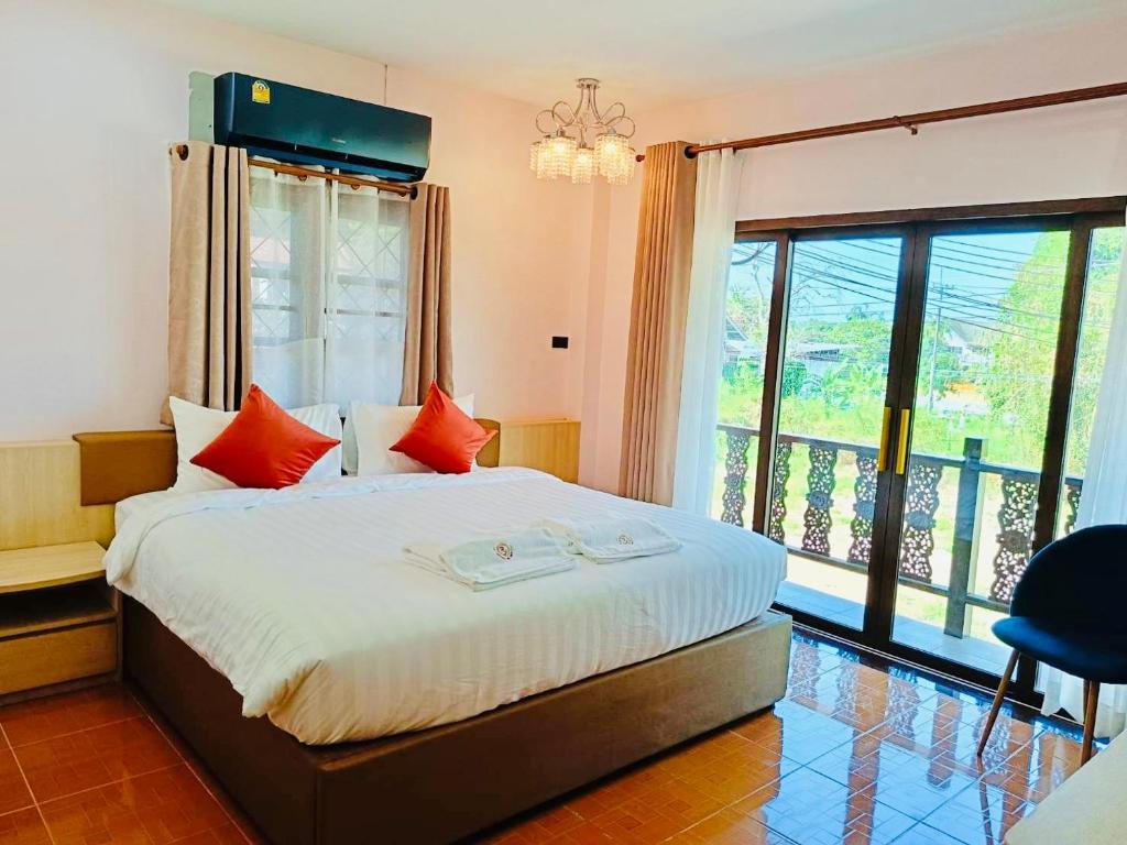 a bedroom with a bed and a large window at Ratana Boutique Resort - Mae Phim in Ban Ang