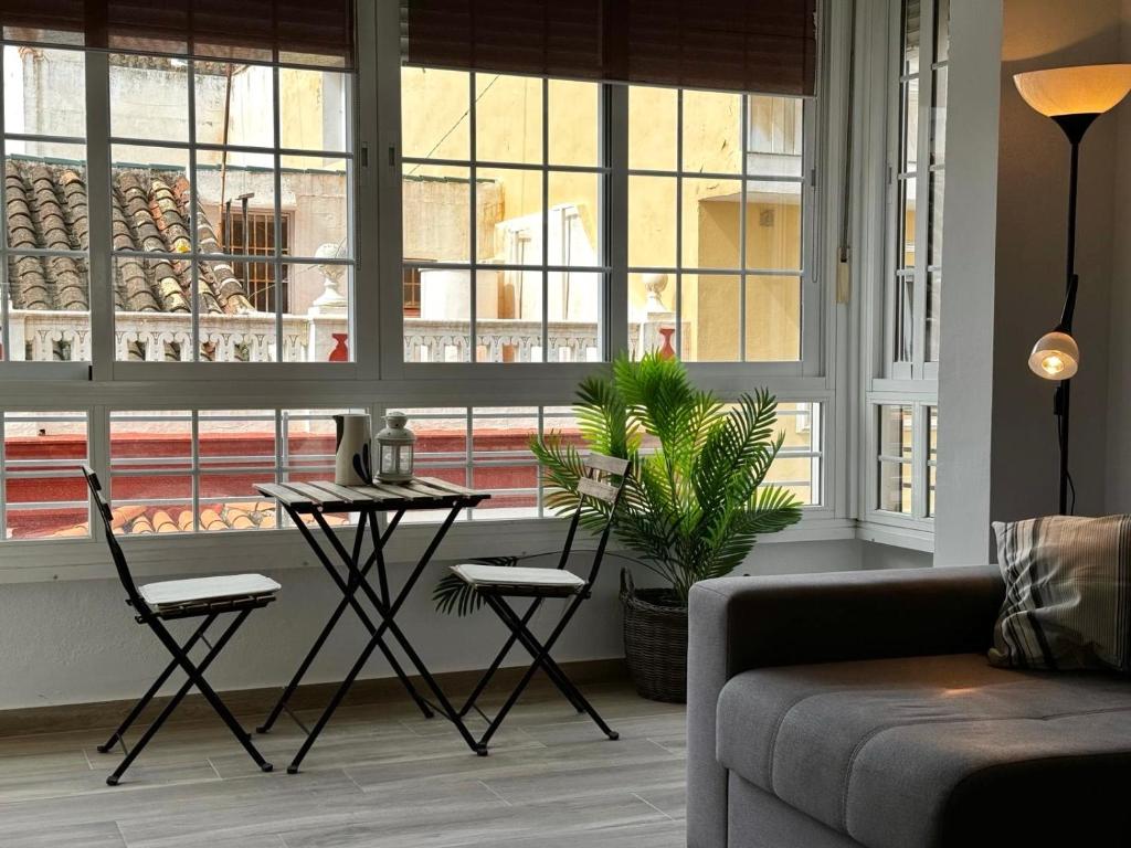 a living room with a table and chairs in front of a window at TuHome Neptuno I in Fuengirola