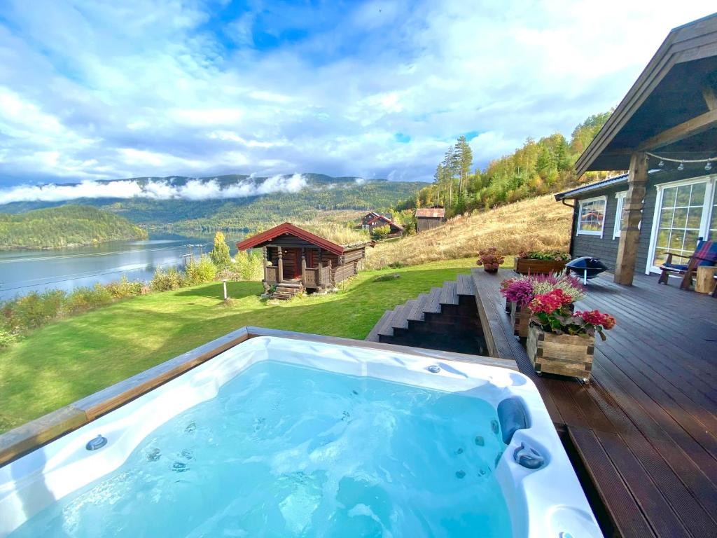 a hot tub on a deck next to a house at Panorama Cabin with 5-bedrooms near Norefjell in Gubberud