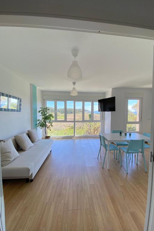 a living room with a white couch and a table at Apartamento muy cerca de la playa in Ribeira