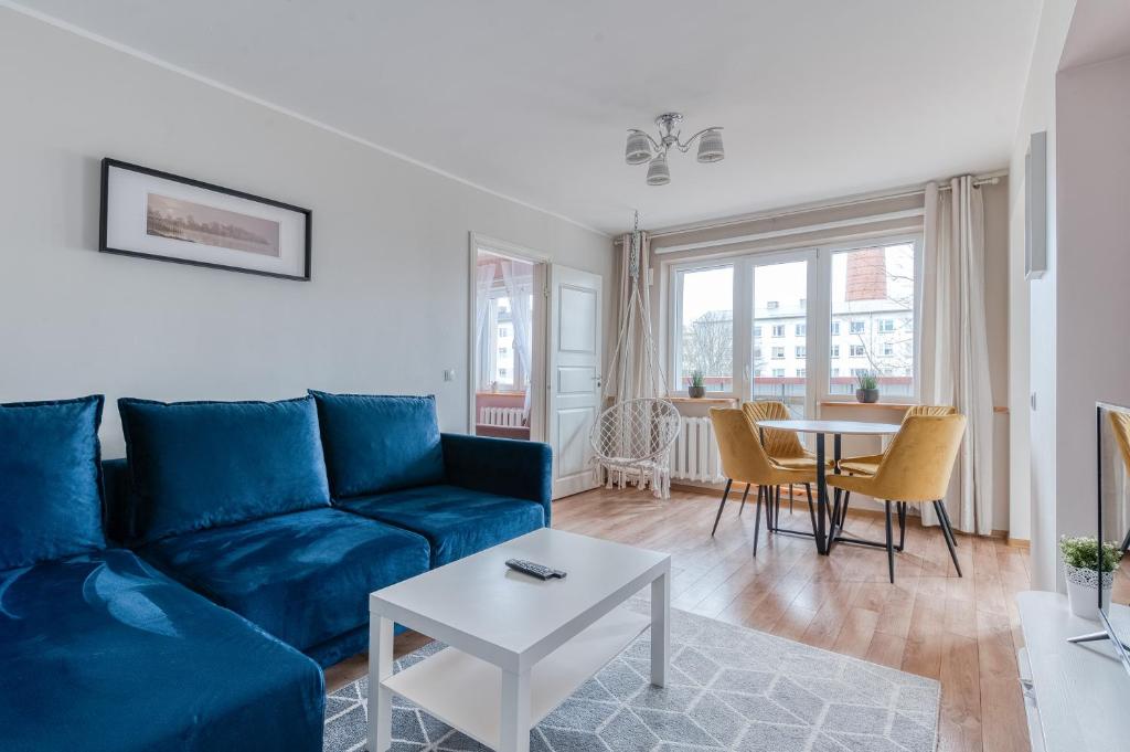 a living room with a blue couch and a table at Kesklinna majutus in Haapsalu