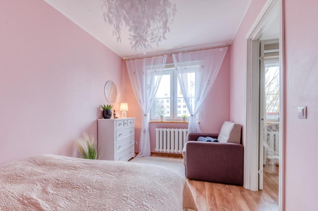 a bedroom with a bed and a chair and a window at Kesklinna majutus in Haapsalu