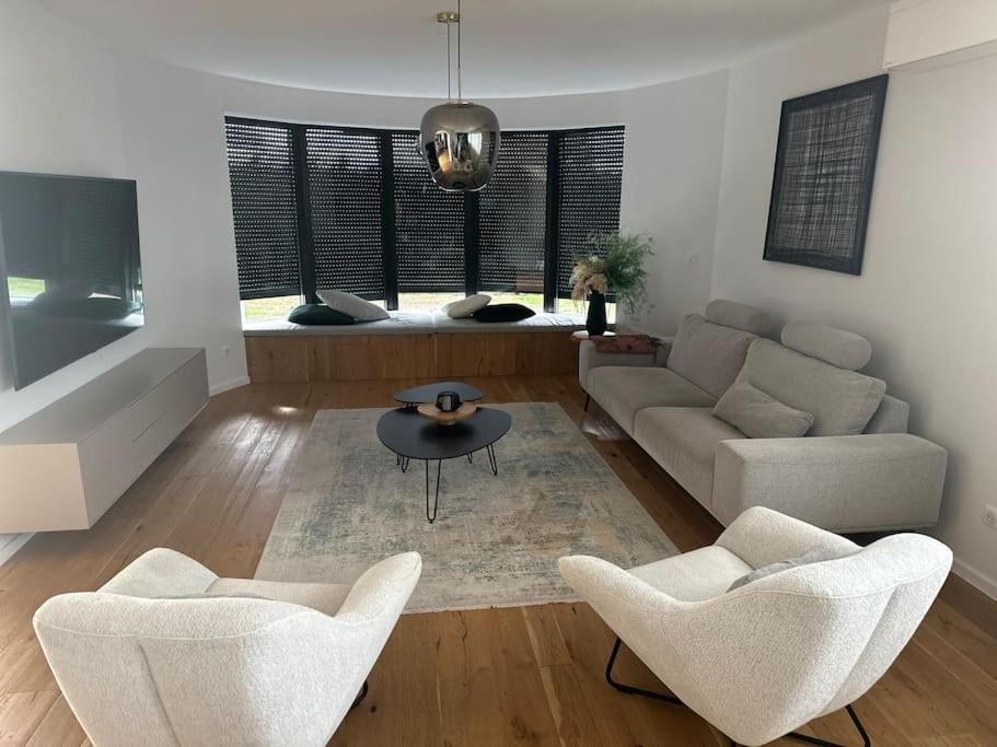 ein Wohnzimmer mit einem Sofa, Stühlen und einem Tisch in der Unterkunft Exceptionnelle Villa 7 min Colmar in Bischwihr
