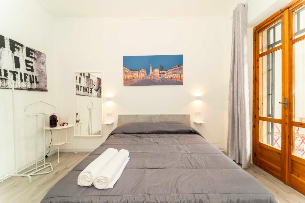 SUITE INALPI ARENA STADIO OLIMPICO TORINO في تورينو: غرفة نوم عليها سرير وفوط