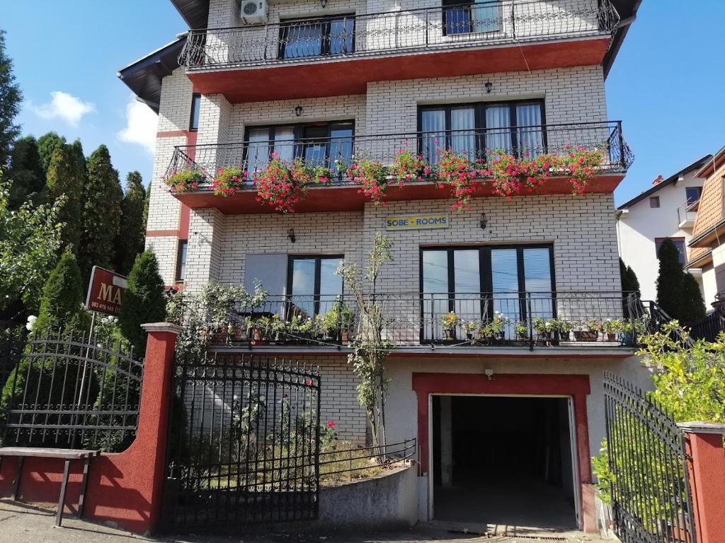 a brick building with flower boxes on the balconies at Smeštaj - sobe MARVEL in Niš