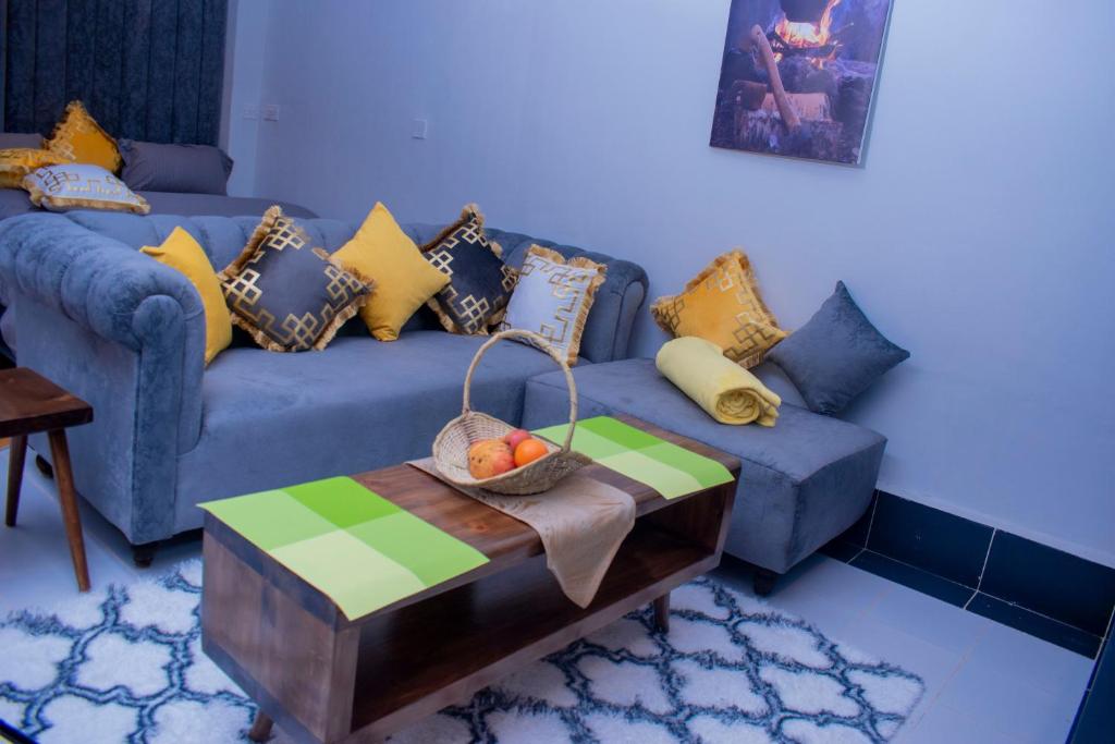 a living room with a blue couch and a table at Superb High spec Studios . Kabete. 15 Mins from Westlands in Nairobi