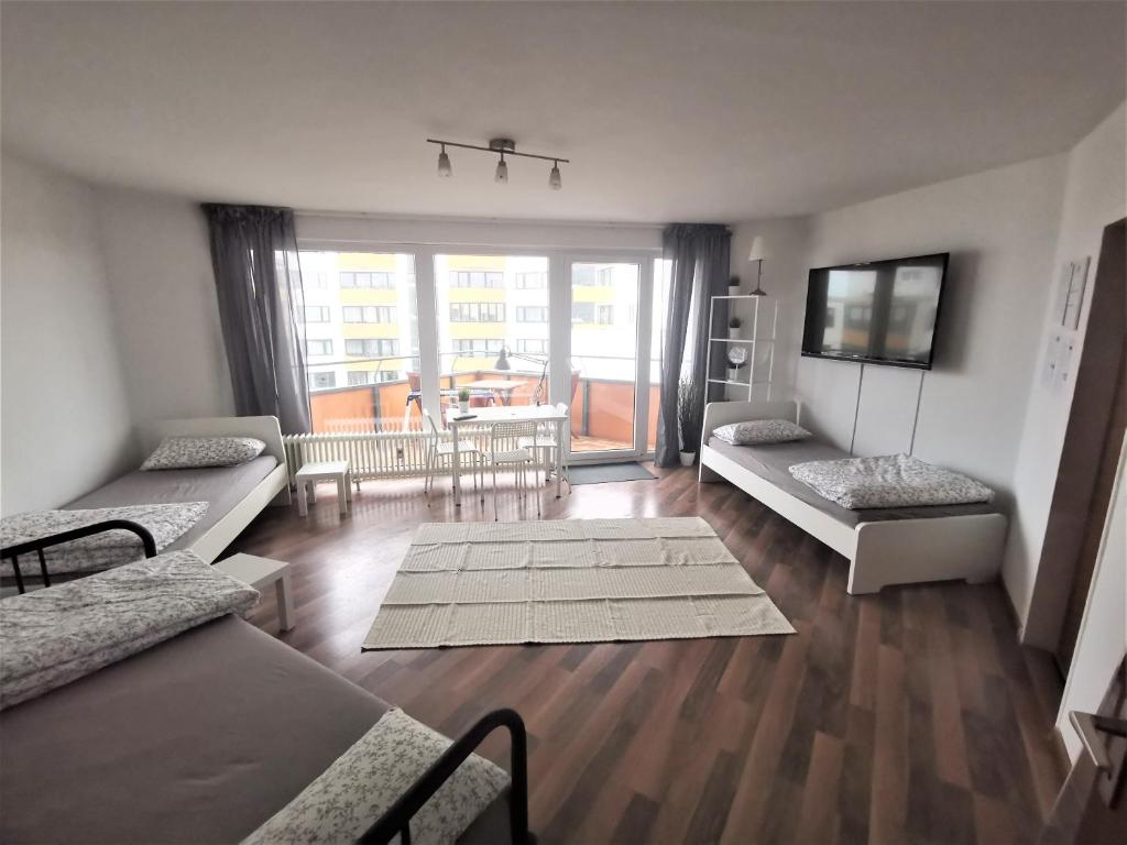 een woonkamer met 2 bedden en een balkon bij one Room Apartment 15 min to Fair in Hannover