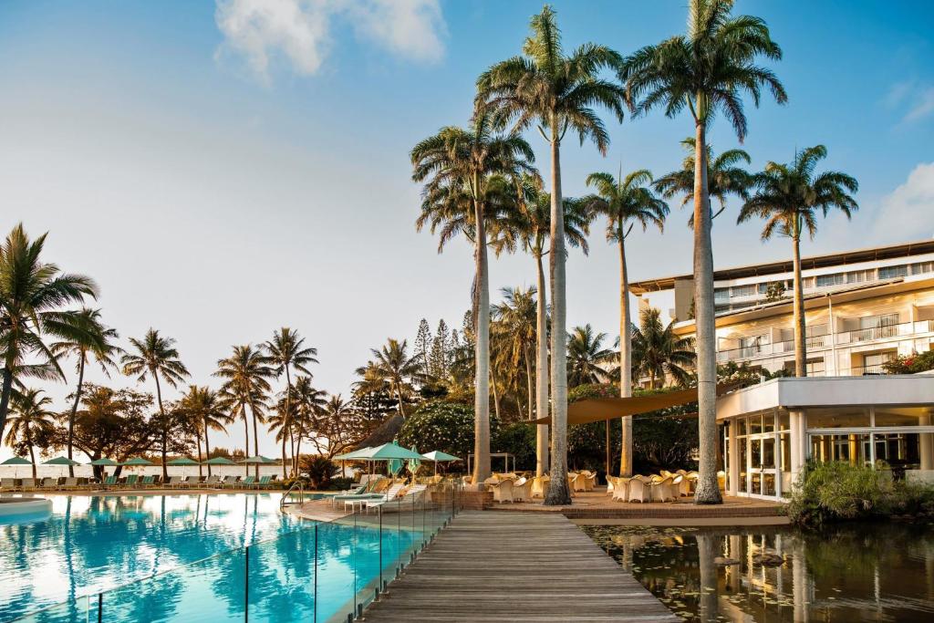 un resort con piscina, palme e un edificio di Le Méridien Nouméa Resort & Spa a Noumea