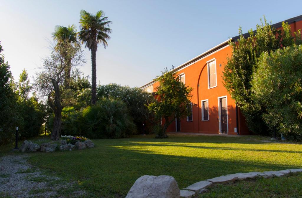 Polesine Camerini的住宿－Agriturismo La Violetta，一座橘色的建筑,在院子里种着棕榈树