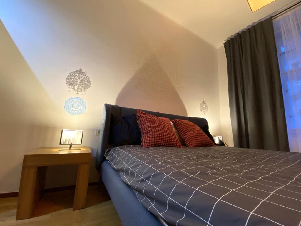 ein Schlafzimmer mit einem blauen Bett, einem Nachttisch und einem Fenster in der Unterkunft Golem in Prag