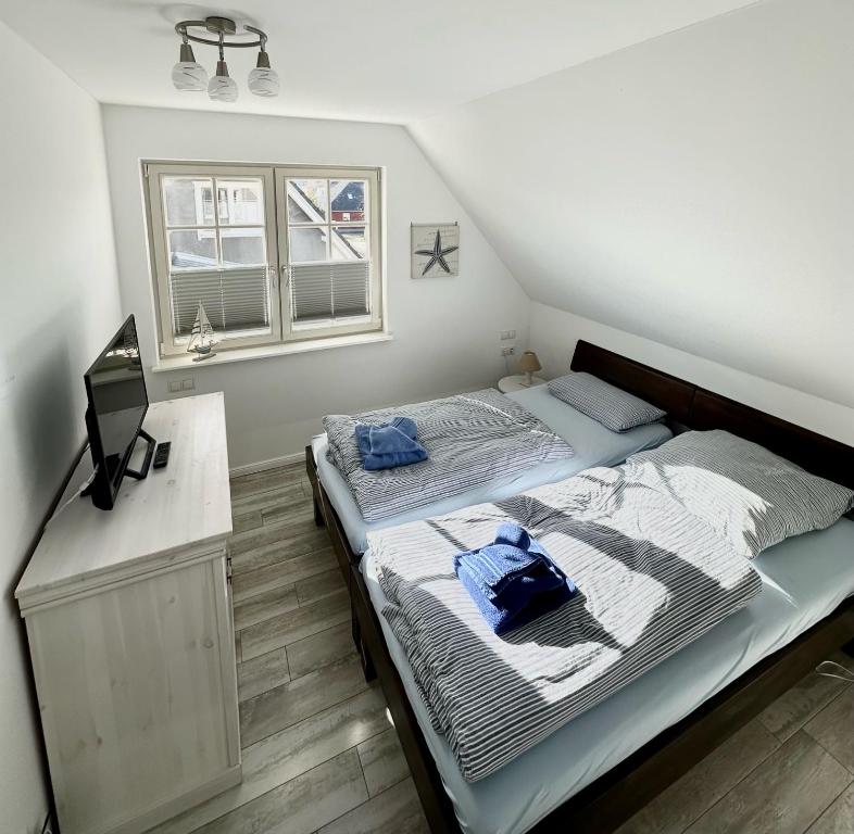 a bedroom with a bed with two blue pillows on it at Dünenperle in Zingst