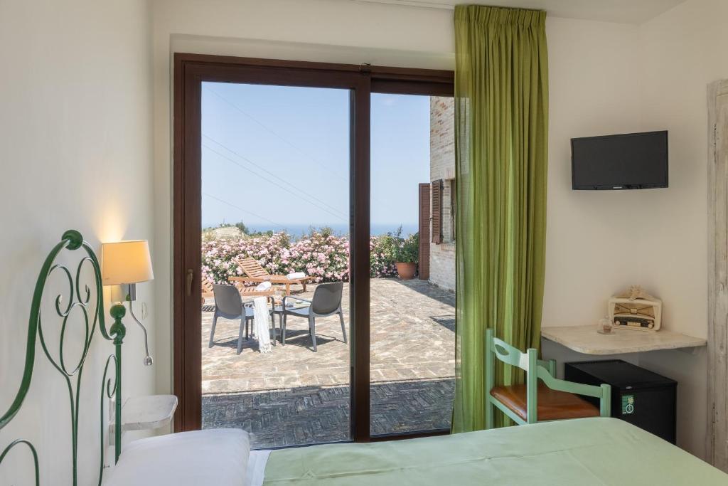 una camera con letto e porta scorrevole in vetro di Villa Cri Cri B&B di Charme a San Benedetto del Tronto