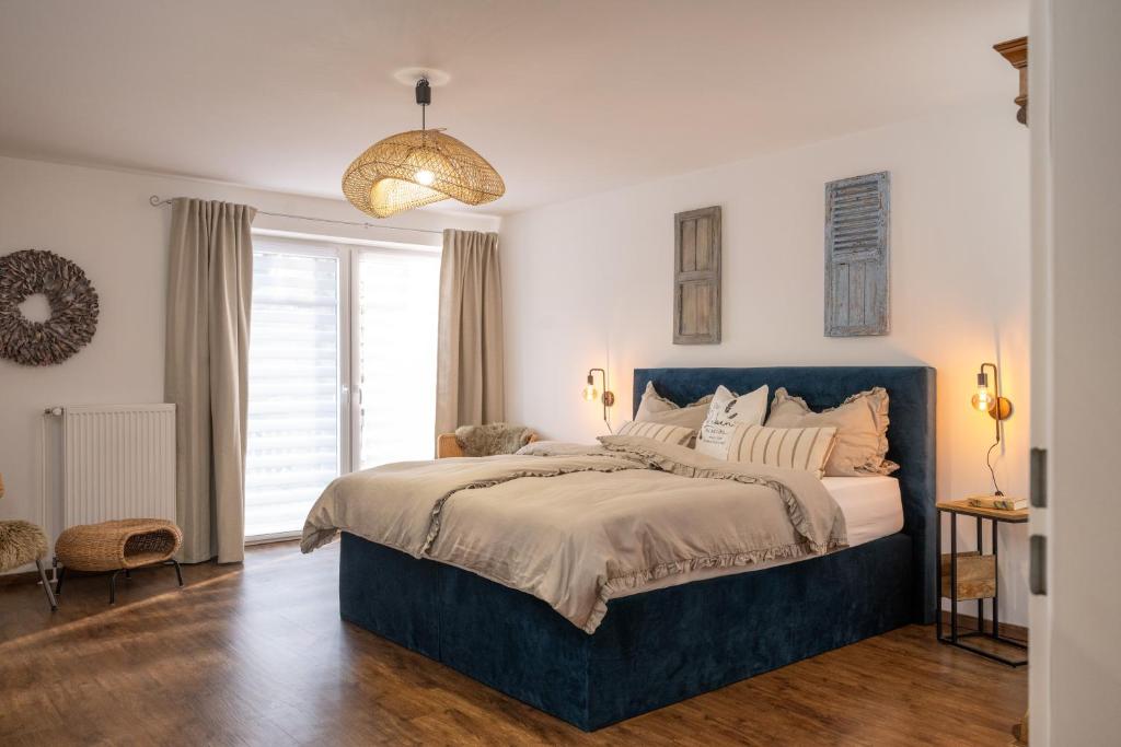 1 dormitorio con 1 cama grande y cabecero azul en Kleiner Storch - Seehotel Dümmer, en Hüde