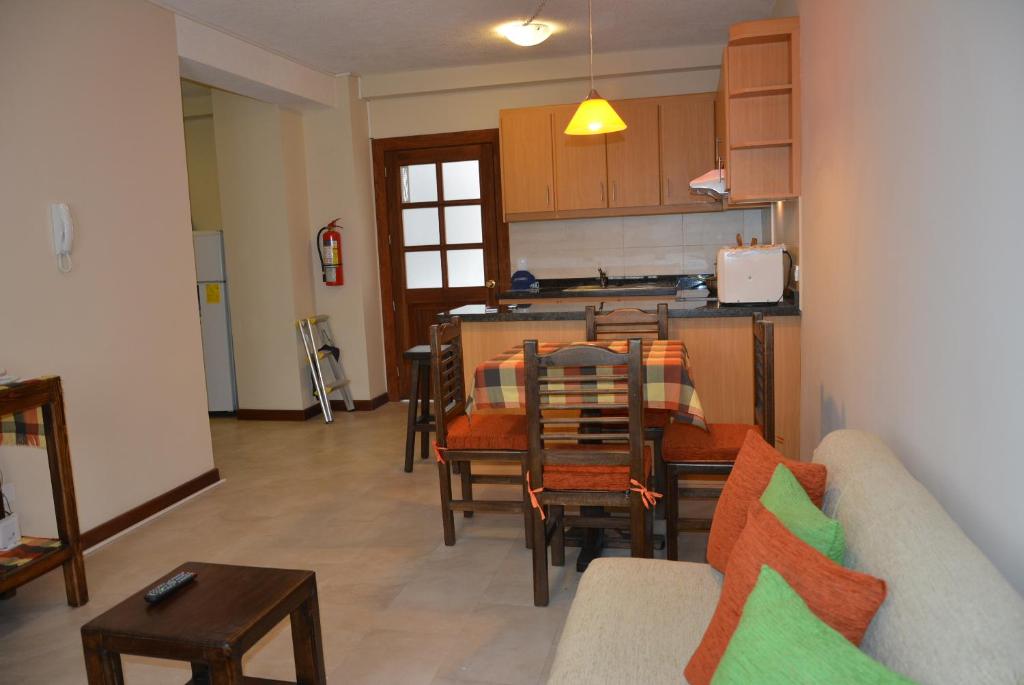 a living room with a couch and a table and a kitchen at Beautiful Place Apartment in Quito