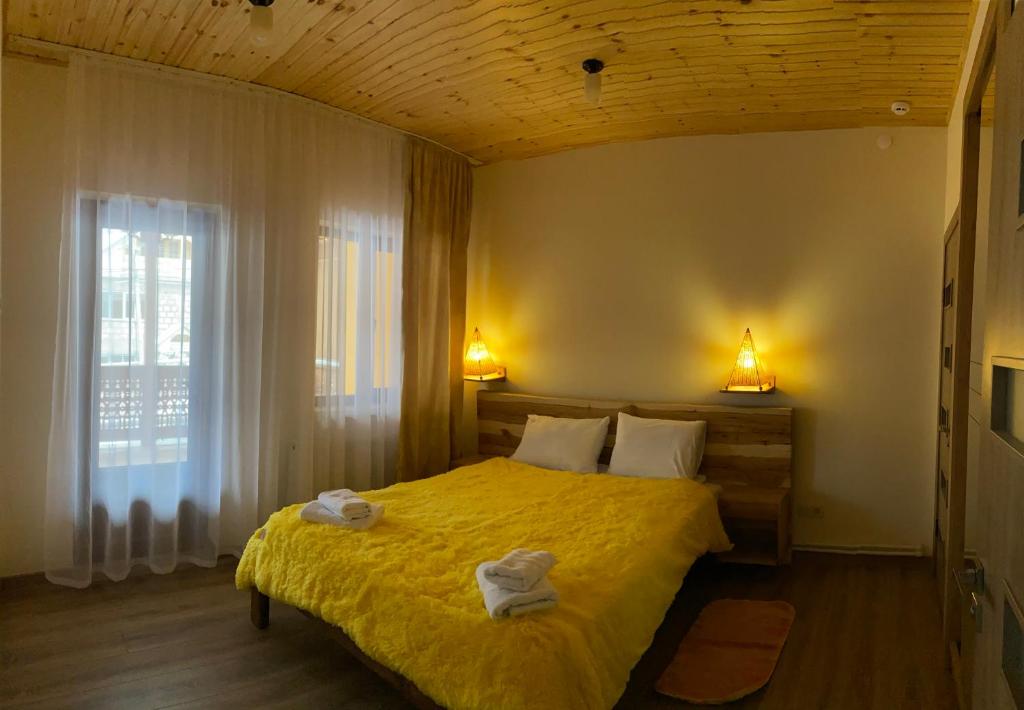 Un dormitorio con una cama amarilla con toallas. en CELENTANO, en Dilijan