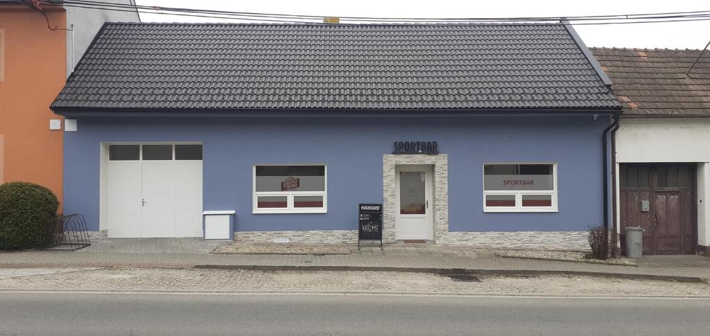 una casa azul con una puerta blanca en una calle en Sportbar, 
