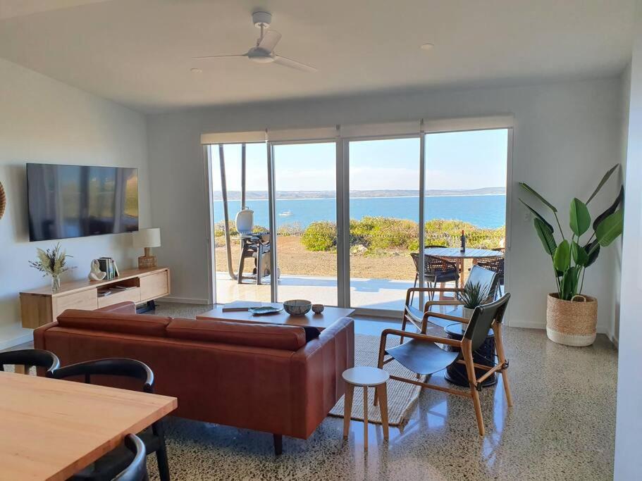 a living room with a couch and a view of the ocean at Wild Retreat - Luxury Home with Magnificent Views in Vivonne Bay