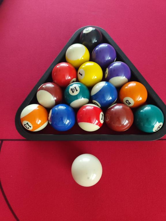 a tray of pool balls on a pool table at Al Raya Hotel Apartments in Dubai