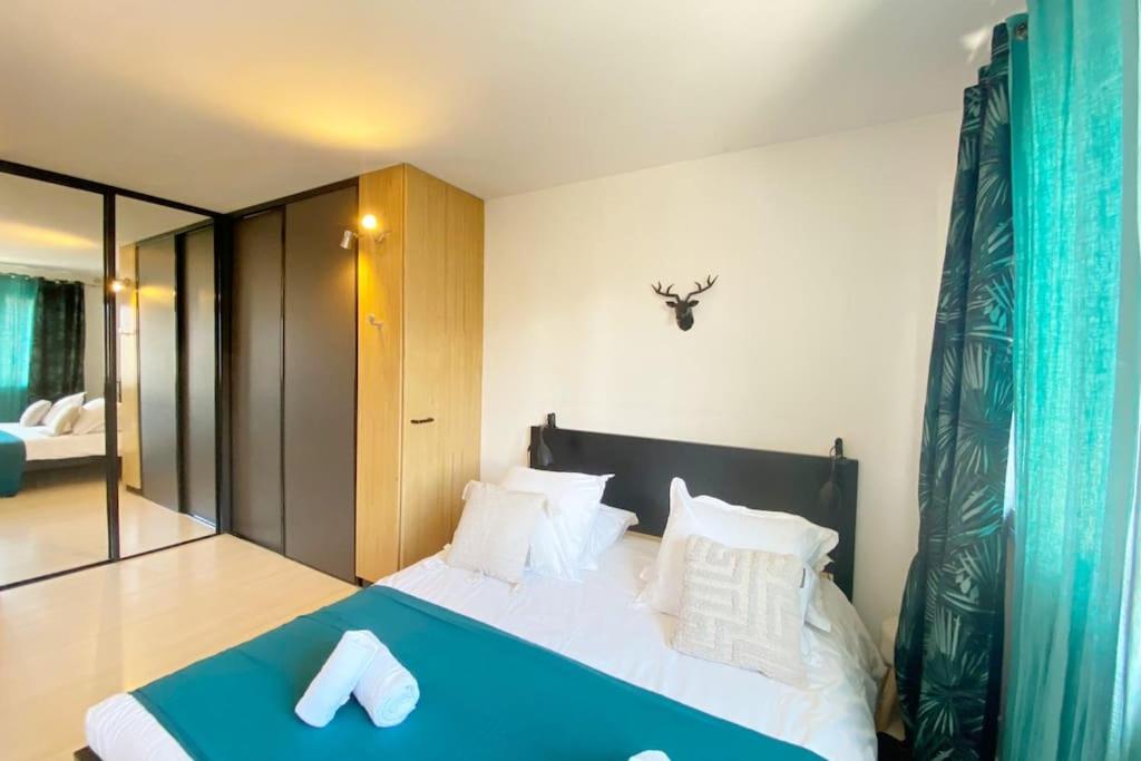 - une chambre avec un lit doté de draps bleus et d'oreillers blancs dans l'établissement Amazone, centre-ville & parking, à Annecy