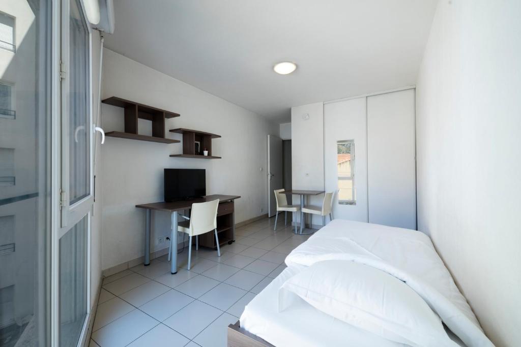 une chambre avec un lit et un bureau avec un ordinateur dans l'établissement Garden & City Toulon, à Toulon