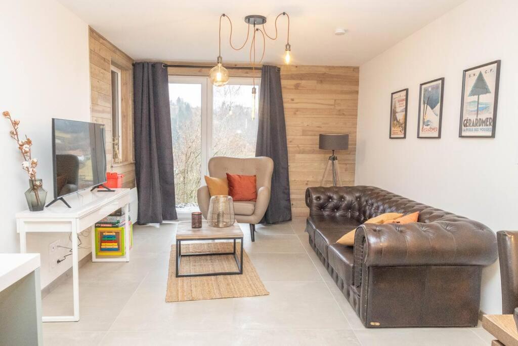 - un salon avec un canapé en cuir et une chaise dans l'établissement Le refuge des Gouttridos, imprenable vue lac 4-5p, à Gérardmer