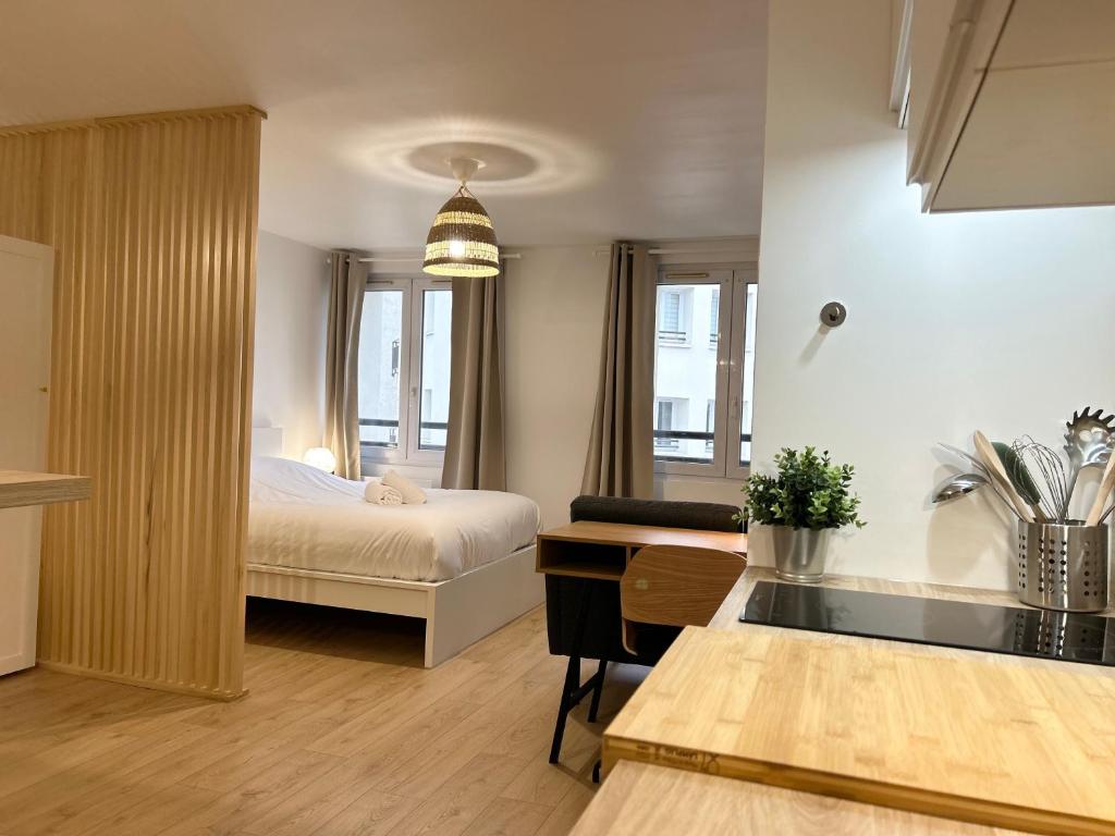 a hotel room with a bed and a desk and a kitchen at Appartement place de la république - Lille in Lille