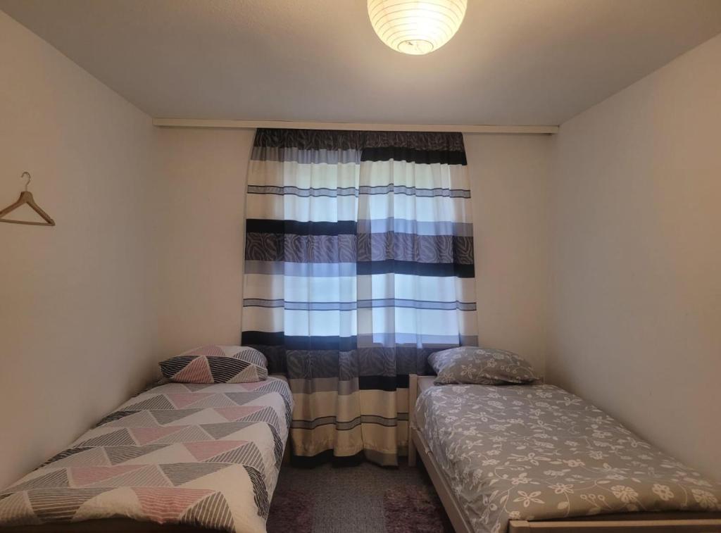 niewielka sypialnia z 2 łóżkami i oknem w obiekcie Perfect Resting Rooms w Bremie