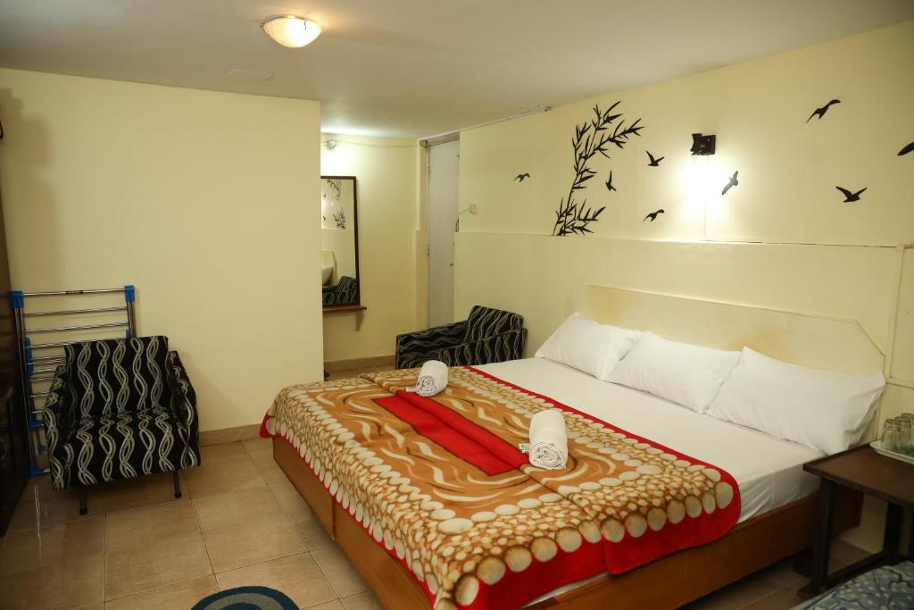 a bedroom with a bed with birds on the wall at DASWAL GARDEN HOME in Madikeri