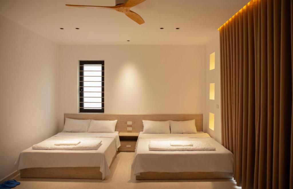 a bedroom with two beds and a window at Light House Motel 978 in Long Hai