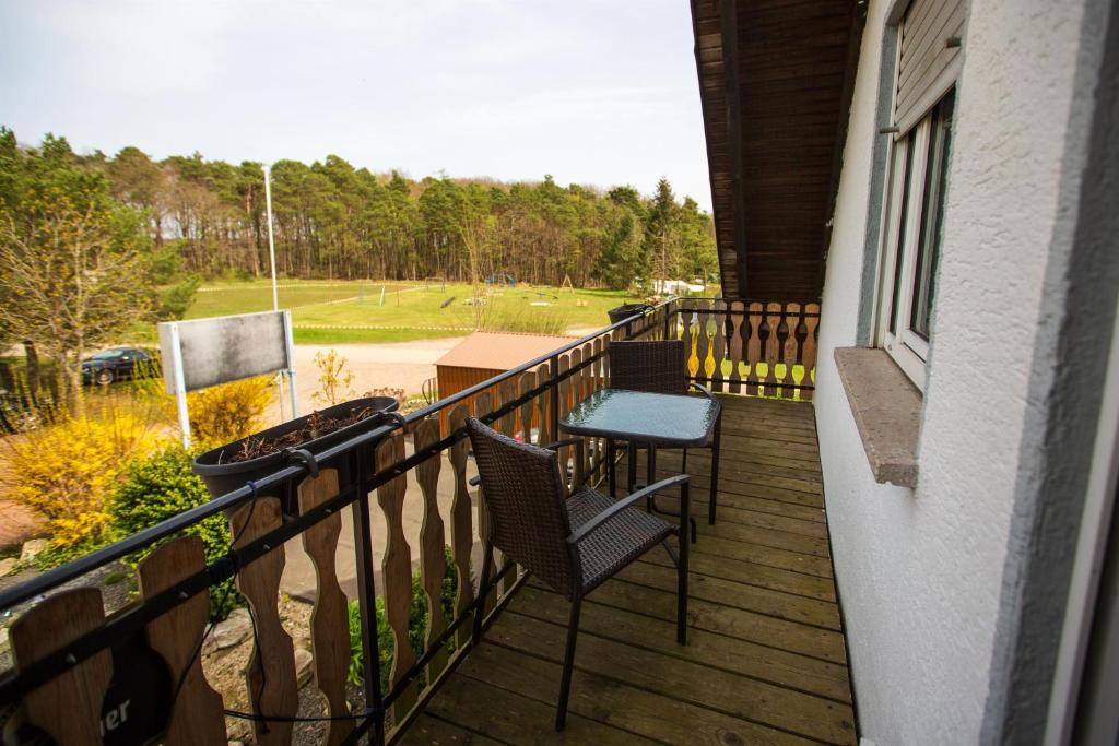 Un balcón con 2 sillas, una mesa y un campo de golf. en Kröver Berg, en Kröv