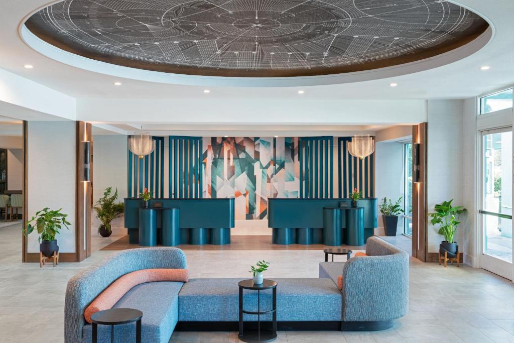 um átrio com sofás azuis e um tecto circular em Hotel Landy Orlando Universal Blvd, a Tribute Portfolio Hotel em Orlando