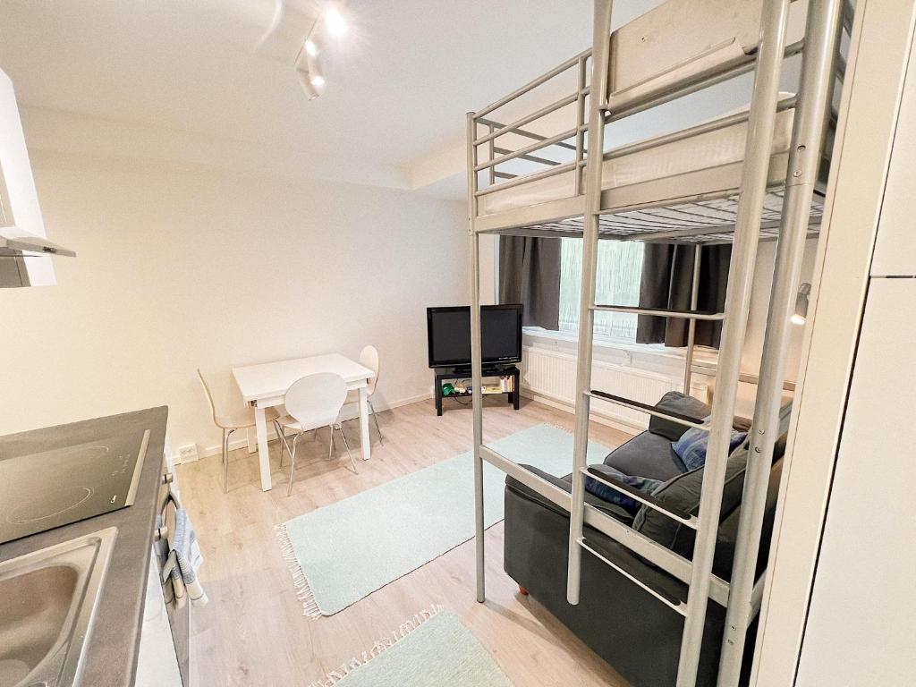 a living room with a bunk bed and a kitchen at ~ A modern flat at a calm ground floor ~ in Espoo