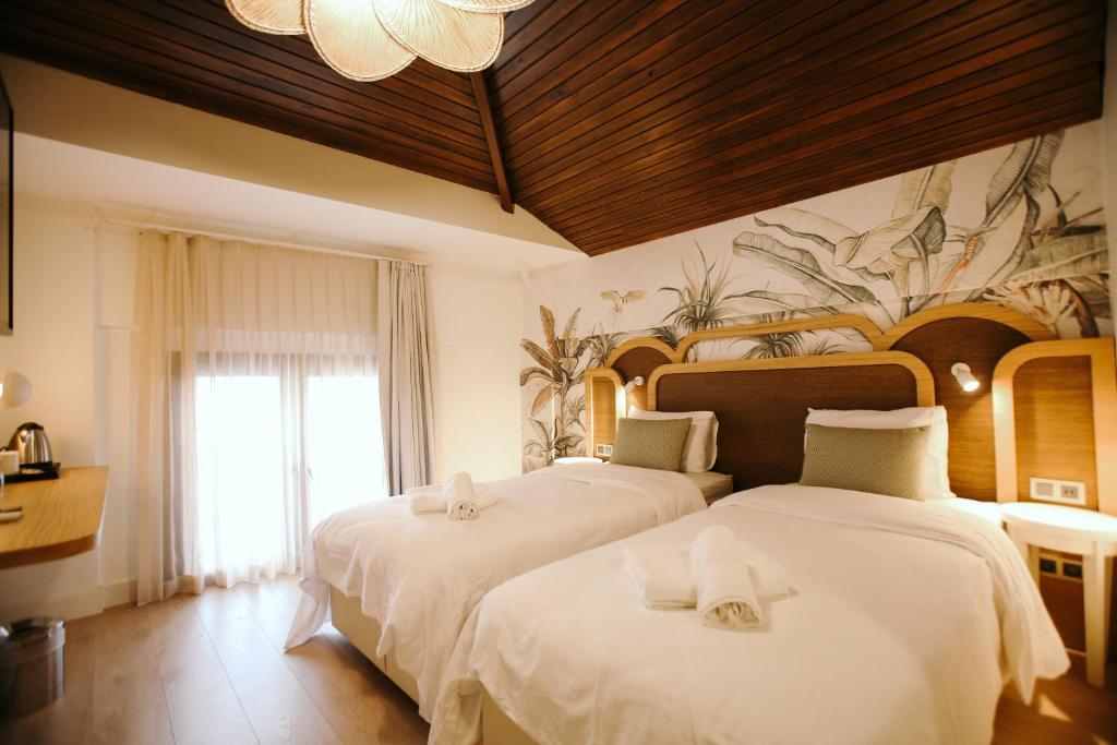 um quarto com 2 camas e lençóis brancos em IMMYS em Seferihisar