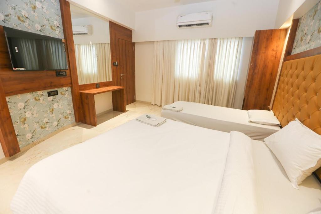 a bedroom with a large white bed and a television at SAHARA LODGING & BOARDING in Mire