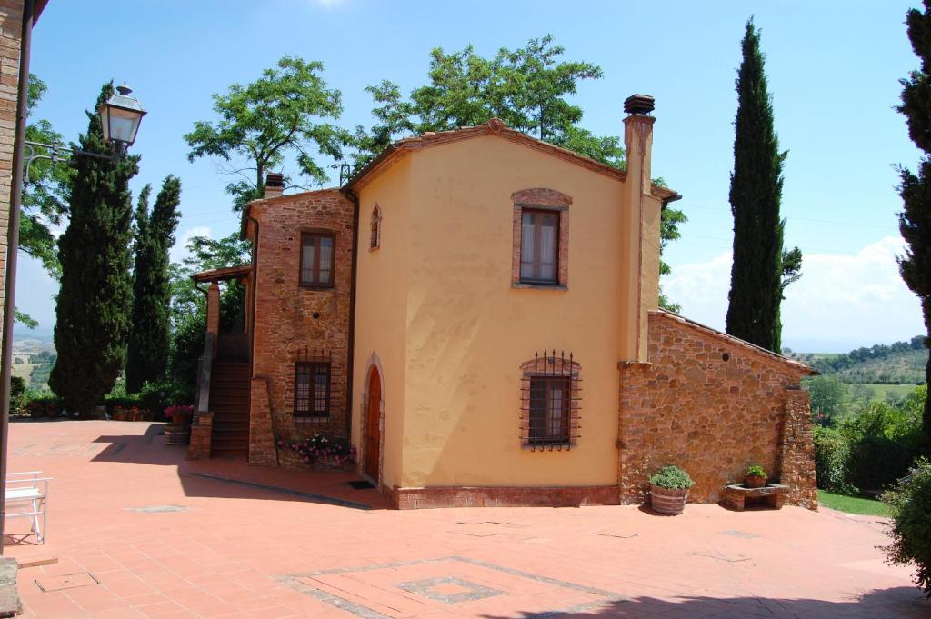 an old building with trees in the background at Comiti Farmhouse Apt Bondone in Montaione